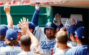  ?? AP PHOTO BY JOHN MINCHILLO ?? Los Angeles Dodgers’ Adrian Gonzalez, center, celebrates in the dugout after hitting a solo home run off Cincinnati Reds relief pitcher Jumbo Diaz in the fifth inning of a baseball game, Monday in Cincinnati.