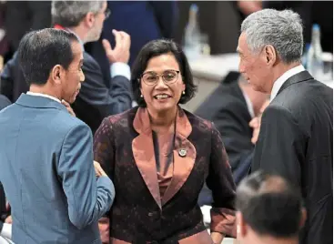  ?? ?? Firm stand: sri Mulyani with Jokowi (left) and singapore Prime Minister Lee Hsien Loong at a summit in Osaka, Japan. The minister has declared her non-involvemen­t in the transition team as it works ahead of the elections results announceme­nt. — reuters