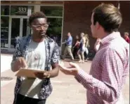  ?? SCOTT BAUER — THE ASSOCIATED PRESS ?? In this Thursday photo, University of Wisconsin freshman Kellen Sharp, left, gets informatio­n about registerin­g to vote from NextGen America worker Sean Manning, right, in Madison, Wis. Sharp says he’s excited to vote. He and others at the Madison event think young people are more energized than ever.