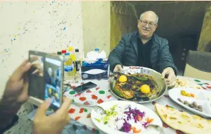  ?? (Ari Jalal/Reuters) ?? A RESTAURANT named Trump Fish is seen in Duhok on Sunday, where a diner takes a picture of a meal of roasted carp (right photo). The restaurant has garnered enmity from some quarters, including online critics who accuse the owner of being an American...