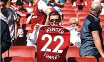  ?? TONY O’BRIEN/REUTERS ?? SALAM PERPISAHAN: Fans memamerkan kostum nomor 22 sebagai simbol durasi pengabdian Arsene Wenger di Arsenal.