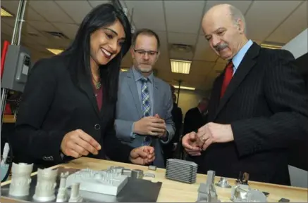  ?? BRENT DAVIS, RECORD STAFF ?? Federal Small Business Minister Bardish Chagger, left, and Ontario Research, Innovation and Science Minister Reza Moridi look at parts and samples printed in the additive manufactur­ing lab at the University of Waterloo on Wednesday with lab managing...