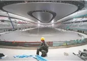  ?? THOMAS PETER / REUTERS ?? A constructi­on worker sits in the National Speed Skating Oval, one site for the 2022 Winter Olympics in Beijing.