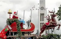  ??  ?? The main attraction, Santa, letting loose with the lollies.