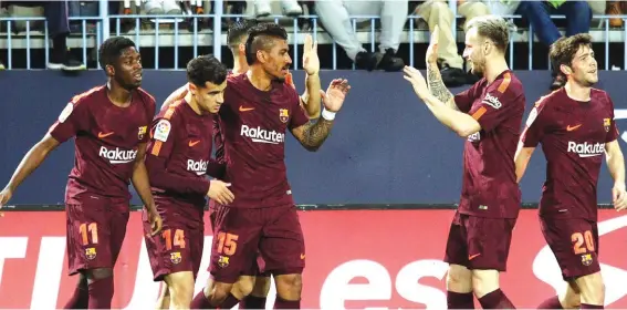  ??  ?? Barcelona’s Coutinho celebrates with team mates scoring his side’s 2nd goal against Malaga Photo: AP