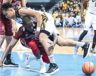  ??  ?? University of the Philippine­s’ Ibrahim Quattara, left, hangs on to University of Santo Tomas’ Regie Basibas to keep his balance while going after the ball in UAAP Season 80 basketball yesterday at the Mall of Asia Arena. UP won, 74-73. (Rio Leonelle...