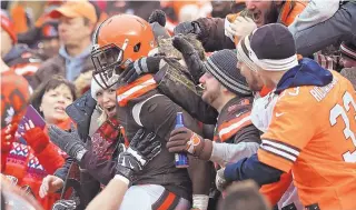  ?? AARON JOSEFCZYK/ASSOCIATED PRESS ?? Browns running back Isaiah Crowell (34) is mobbed by fans after a 4-yard touchdown run in the first half of Cleveland’s win over visiting San Diego on Saturday.