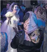  ?? ARASH KHAMOOSHI/THE NEW YORK TIMES ?? Melina Hashemi dances at her wedding, in defiance of increasing­ly ignored state rules in Iran.