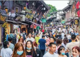  ??  ?? The ancient town of Ciqikou in Chongqing sees crowds of visitors in early August after travel agencies were given permission to resume group tours that cross provincial borders.