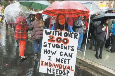  ?? Ringo H.W. Chiu / Associated Press ?? Teachers strike in the rain last week outside John Marshall High School in Los Angeles. Below, elementary school teachers Iris Marin, center, and Mireya Gutierrez, right, and Lorena Redford, clench fists at a rally in downtown Los Angeles on Jan. 18.