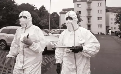  ?? AP ?? Emergency personnel in protective clothing stand in front of a student dormitory in Koblenz, Germany, last week. At one point during the Covid-19 crisis, there was an acute shortage of personal protective equipment in the country