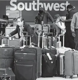  ?? Melissa Phillip / Staff file photo ?? Employees sort luggage for Southwest Airline flights Dec. 22 at Hobby Airport. The author says the Airline Payroll Support Program is a lifeline for Houston.