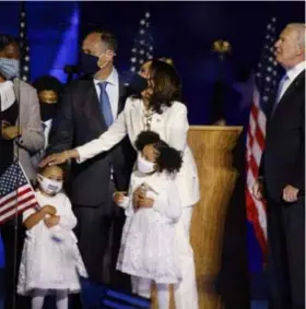  ?? FOTO REUTERS ?? Kamala Harris met haar familie op het podium. Toekomstig president Joe Biden kijkt toe.