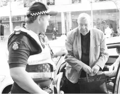  ??  ?? Pell is assisted by an Australian policeman as he gets out of a car upon arriving at the Melbourne Magistrate­s’ Court in Australia in this file photo. — Reuters photo