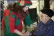  ??  ?? An elf interacts with a senior in Home Instead Senior Care’s Be a Santa to a Senior program.