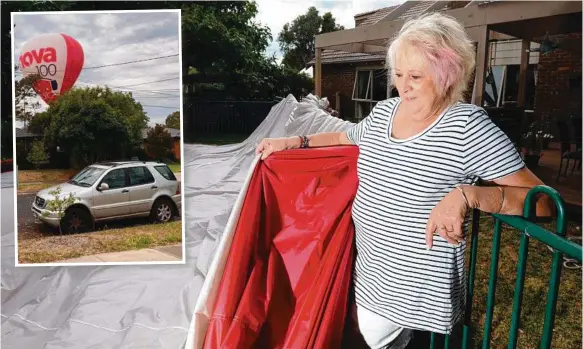  ?? Picture: ANDREW HENSHAW ?? Christine Taylor inspects the hot air balloon that made an emergency landing in her Melbourne yard yesterday morning.