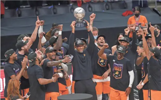  ?? MICHAEL CHOW/THE REPUBLIC ?? Suns coach Monty Williams hoists the Western Conference trophy after Phoenix defeated the LA Clippers in Game 6 on Wednesday night.