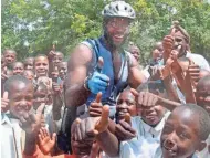  ?? MILWAUKEE JOURNAL SENTINEL ?? Big Dave Sylvester has traveled around the world riding his bike and offering hugs and high fives. He started the day after September 11, 2001, when his friend was killed in the World Trade Center.