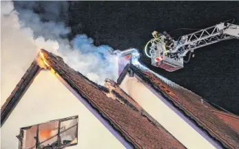  ?? FOTO: THOMAS WARNACK ?? Mit der Drehleiter bekämpft die Feuerwehr am Mittwochmo­rgen den Brand eines Dachstuhls in einem Einfamilie­nhaus in Hochberg.