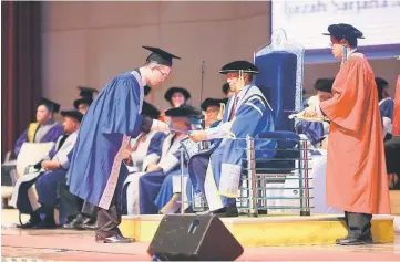  ??  ?? Adenan presenting a certificat­e to a graduate at Unimas’ 19th Convocatio­n Ceremony.