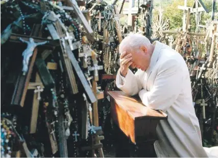  ?? ?? Pope John Paul II praying among the crosses and crucifixes in September 1993. PHOTO: WIKIPEDIA