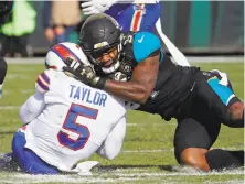  ?? Stephen B. Morton / Associated Press ?? Jacksonvil­le’s Yannick Ngakoue draws a penalty for hitting then-Buffalo quarterbac­k Tyrod Taylor helmet to helmet.