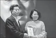  ?? PROVIDED TO CHINA DAILY ?? Chinese filmmaker Cao Jinling (right) was announced as one of the five winners by renowned filmmaker Ming Zhenjiang at the Wu Tianming Film Fund for the Young Talent event in Beijing on April 20.