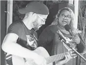  ?? MARTIN MEJIA/AP ?? Venezuelan singer Reymar Perdomo performs with guitarist Omar Rumbos on a beach in San Bartolo, Peru.