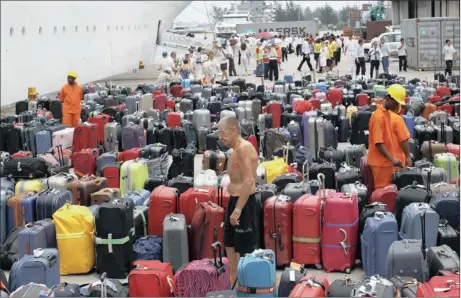  ?? Picture: REUTERS ?? SAFE: A passenger looks for his bags after alighting from the Costa Allegra cruise ship at the port of Mahe in the Seychelles yesterday. The crippled Costa cruise line with more than 1 000 people on board arrived at the capital of Seychelles after...