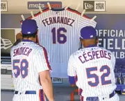  ?? ADAM HUNGER/GETTY IMAGES ?? The Mets’ Yoenis Cespedes and Josh Smoker hang a jersey in honor of Jose Fernandez before facing the Phillies.
