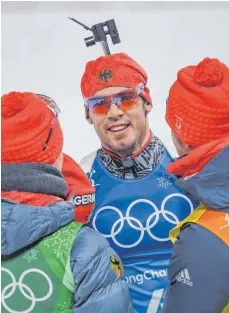  ?? FOTO: DPA ?? Bronze gerettet: Schlussläu­fer Simon Schempp wird von Benedikt Doll (links) und Arnd Peiffer im Ziel erwartet.