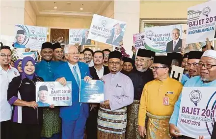  ?? AHMAD IRHAM MOHD NOOR
PIC BY ?? Prime Minister Datuk Seri Najib Razak receiving the memorandum in support of the 2018 Budget from Federation of Malay Students Union president Zambri Mohd Isa (centre) in Putrajaya yesterday.