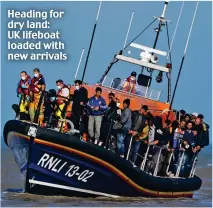  ??  ?? Heading for dry land: UK lifeboat loaded with new arrivals