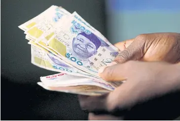  ?? REUTERS ?? A person holds Nigerian naira banknotes.