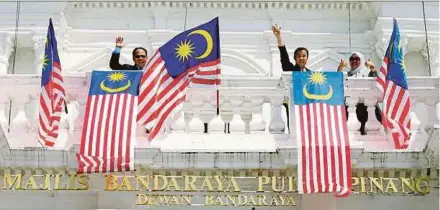  ?? PIC BY MUHAMMAD MIKAIL ONG ?? Penang Island City Council Mayor Datuk Yew Tung Seang (centre) launching the fly-the-Jalur Gemilang campaign at Padang Kota Lama, George Town, yesterday.