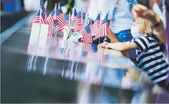  ?? enviado especial / tonito.zayas@gfrmedia.com ?? Un niño observa las pequeñas banderas estadounid­enses colocadas en el memorial en recordació­n a las víctimas de los ataques.