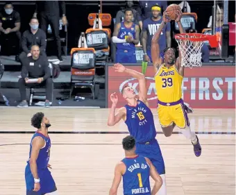  ?? Mark J. Terrill, The Associated Press ?? Denver's Jamal Murray, left, Michael Porter Jr. ( 1) and Nikola Jokic ( 15) defend as Dwight Howard of the Lakers goes up to dunk the ball during Friday’s Game 1.