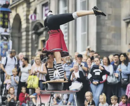  ??  ?? 0 Crowds gather to watch a performer on the Royal Mile in 2019 – last year's Fringe was cancelled due to Covid