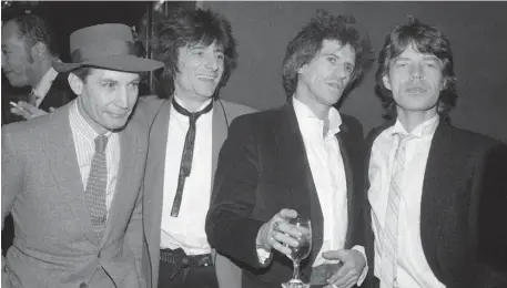  ??  ?? From left, Watts joins the Stones’ Ronnie Wood, Keith Richards and Mick Jagger at an opening-night party for the 1983 film, ‘Let’s Spend The Night Together.’