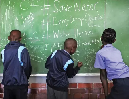  ?? PICTURE: CINDY WAXA/AFRICAN NEWS AGENCY (ANA) ?? PRECIOUS: Children sign their names as part of pledging to save water. Miss Earth SA and ambassador­s paid a visit to Prestwich Primary in Green Point as part of the #SaveWater #EveryDropC­ounts school roadshow.