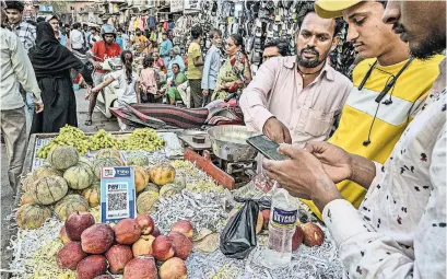  ?? ATUL LOKE FOR THE NEW YORK TIMES ?? Scan-and-pay systems have become common for even the smallest purchases in India. A fruit stall in Mumbai.