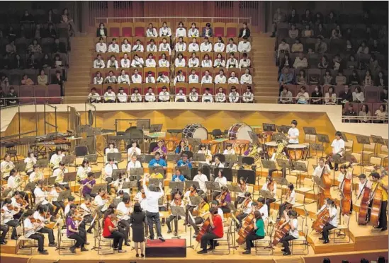  ?? Sam Comen ?? AT A PUBLIC REHEARSAL in Tokyo, Gustavo Dudamel conducts YOLA members and their counterpar­ts in a Japanese El Sistema-styled orchestra.