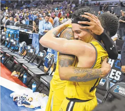  ?? KENNETH K. LAM/BALTIMORE SUN ?? UMBC’s Jairus Lyles, left, consoles K.J. Maura after Sunday night’s 50-43 loss to Kansas State in the second round of the NCAA men’s basketball tournament in Charlotte, N.C.