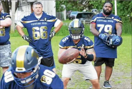  ?? STAN HUDY - SHDUY@DIGITALFIR­STMEDIA.COM ?? Troy Fighting Irish quarterbac­k Zack Deering takes a snap during the last practice prior to Saturday’s 2018season opener at Lansingbur­gh High School. Veterans Allen Preston (66) and Kejana Jackson (79) look on.