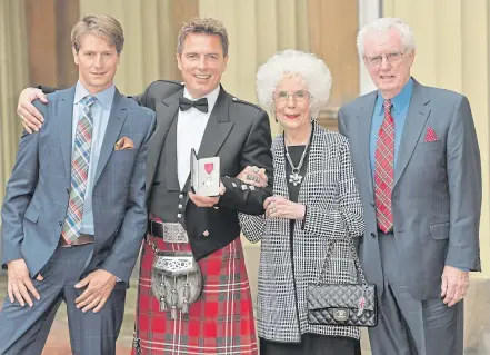  ??  ?? ▼ The pride of Scotland: the I’m A Celeb star after being awarded the MBE with Scott and his mum and dad, Marion and John.