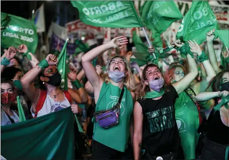  ?? NATACHA PISARENKO — THE ASSOCIATED PRESS ?? Activists watch live video streaming of lawmakers in session in Buenos Aires, Argentina, on Wednesday, 2020. Congress approved a bill that legalize abortion.