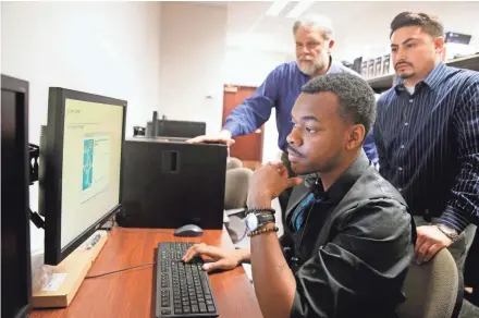  ?? JOURNAL SENTINEL PHOTOS BY RICK WOOD/MILWAUKEE ?? Avery White learns to program computers at Twin Disc Corp. under a new jobs training program in Racine called Start IT. Twin Disc supervisor Joshua Sosa (right) helps White. Also watching is Cory Mason, chief informatio­n officer at Twin Disc who helped...
