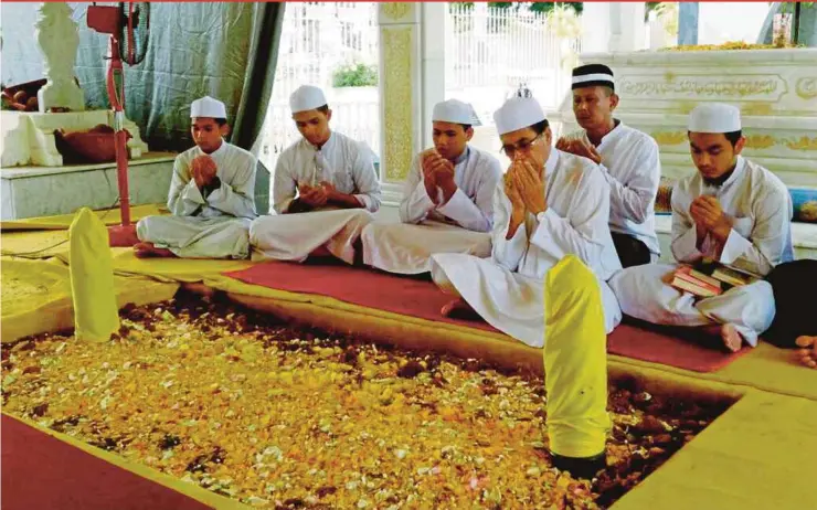  ?? PIC BY NOORAZURA ABDUL RAHMAN ?? People reciting prayers at Sultan Abdul Halim Mu’adzam Shah’s grave at the Kedah Royal Mausoleum in Alor Star yesterday.