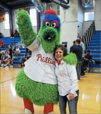  ?? JOHN BLAINE — FOR THE TRENTONIAN ?? The Sunshine Foundation’s Cathy Dicostanzo poses for a photo with the Phillie Fanatic at the 3-Point and Dunk Contests the Sunshine Foundation hosted alongside WBCB at TCA last week.