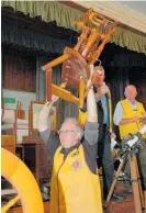  ??  ?? Katikati Lions Club Gerald Paterson holds up a spinning wheel which went under the hammer for $65 at the Lions Monster Garage Sale and Steptoes Auction.